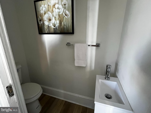 bathroom featuring hardwood / wood-style flooring, vanity, and toilet