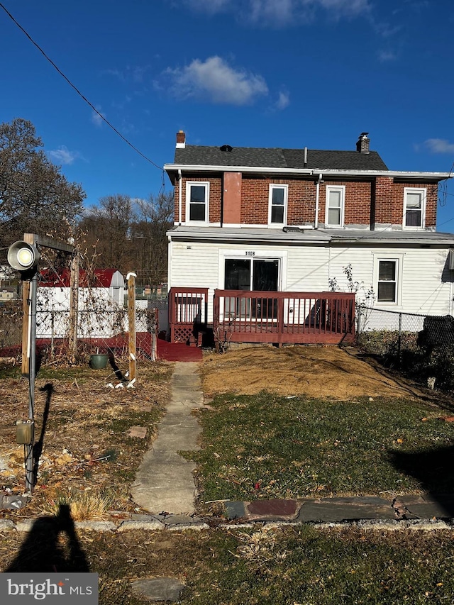 back of property featuring a lawn and a wooden deck