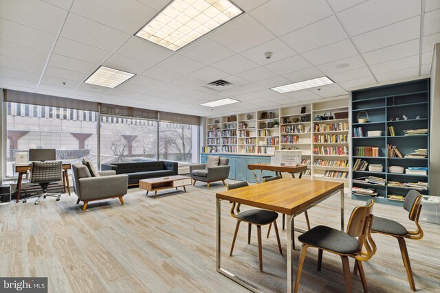 dining area with hardwood / wood-style flooring and a drop ceiling