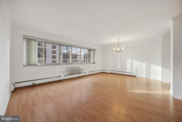 spare room featuring a wall mounted air conditioner, a baseboard heating unit, a chandelier, light hardwood / wood-style floors, and ornamental molding