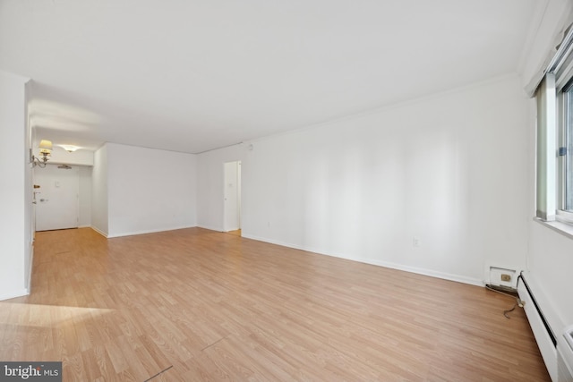 spare room with a baseboard radiator and light wood-type flooring