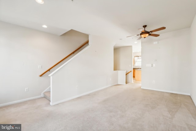 unfurnished living room featuring light carpet and ceiling fan