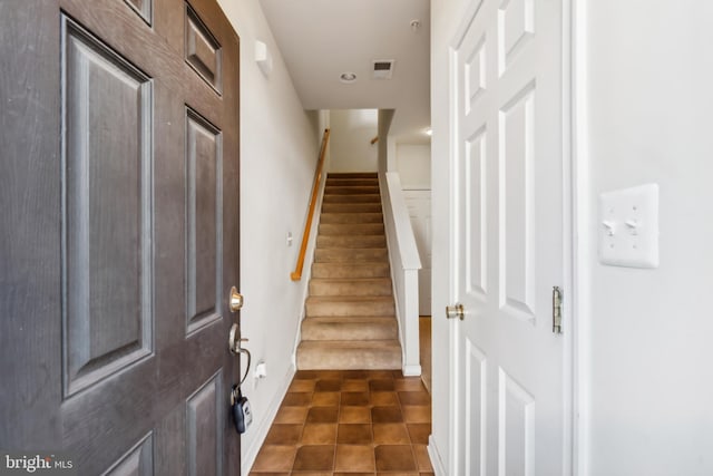 foyer featuring dark tile patterned flooring