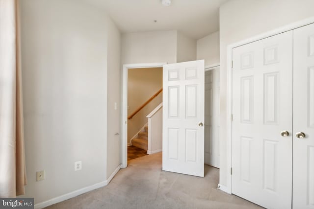 unfurnished bedroom featuring a closet and light colored carpet