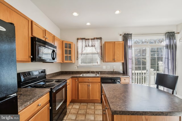 kitchen featuring black appliances, a center island, and sink