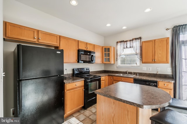 kitchen with sink, a center island, and black appliances