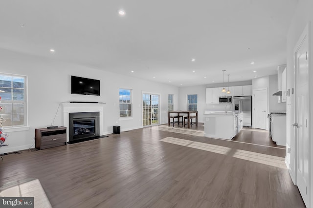 unfurnished living room featuring light hardwood / wood-style flooring and sink