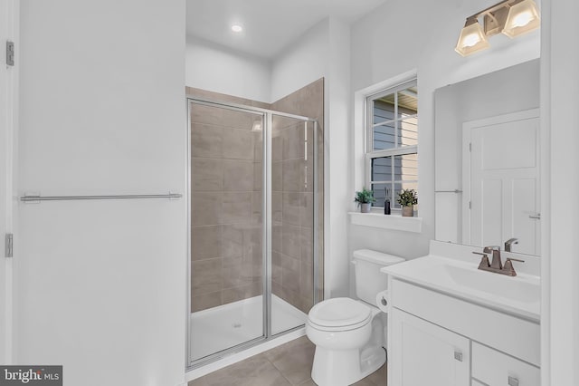 bathroom featuring tile patterned floors, vanity, toilet, and walk in shower