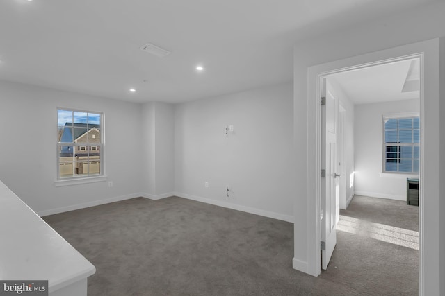 spare room featuring dark colored carpet