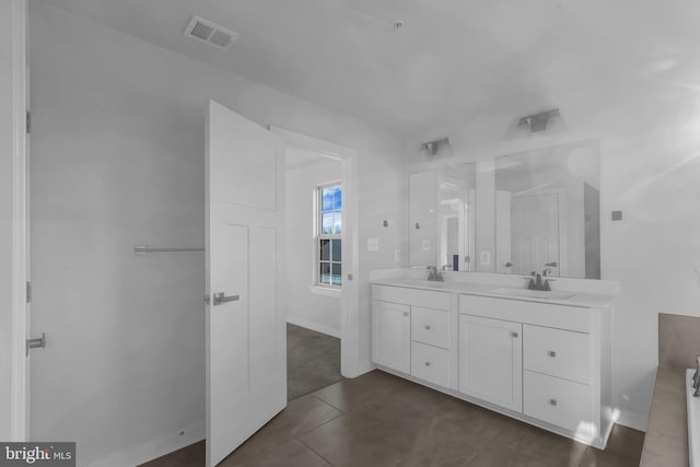 bathroom with a bath, vanity, and tile patterned floors