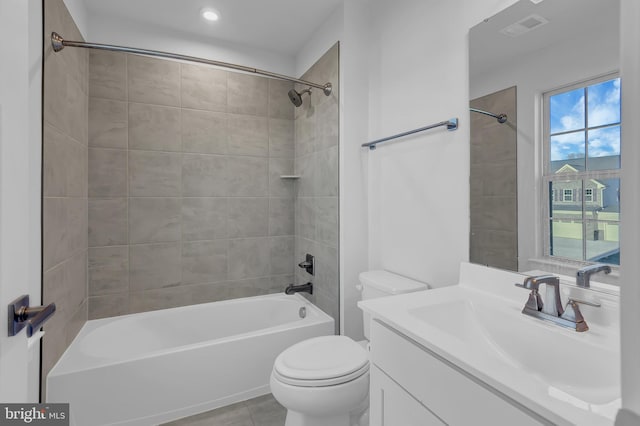 full bathroom featuring tiled shower / bath, tile patterned flooring, vanity, and toilet