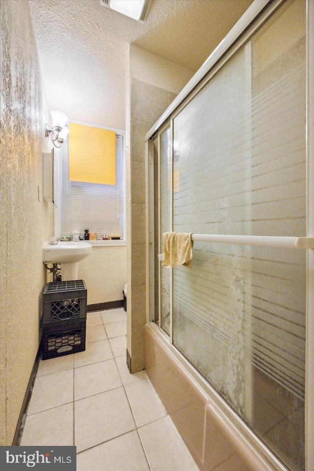 5122 N Broad St, Philadelphia, PA 19141 - bathroom featuring tile patterned flooring, a textured ceiling, sink, and bath / shower combo with glass door