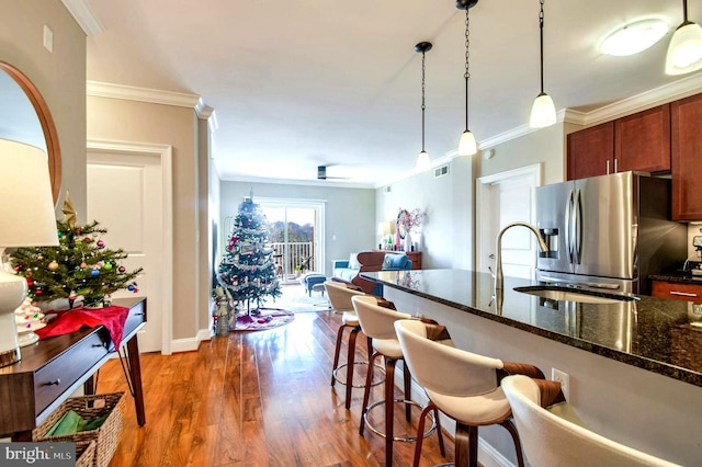 kitchen featuring crown molding, dark hardwood / wood-style floors, ceiling fan, decorative light fixtures, and stainless steel fridge with ice dispenser