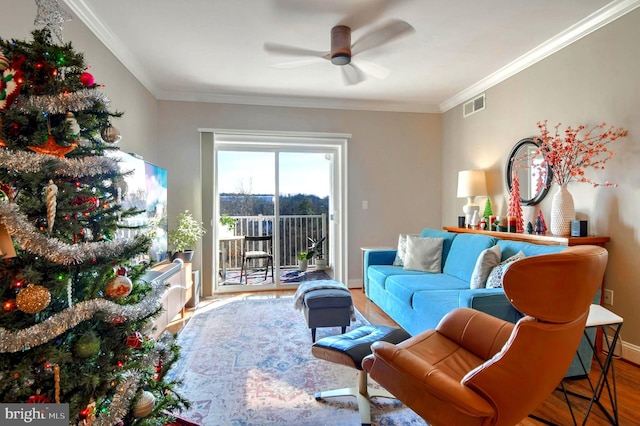 living room featuring ceiling fan, ornamental molding, and hardwood / wood-style flooring