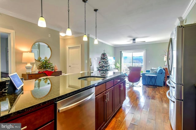 kitchen featuring appliances with stainless steel finishes, ceiling fan, crown molding, hardwood / wood-style flooring, and dark stone countertops