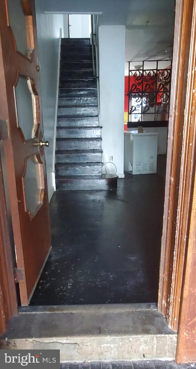 staircase featuring concrete floors