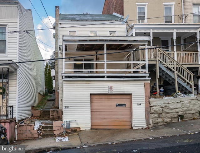 back of property featuring a garage and a balcony