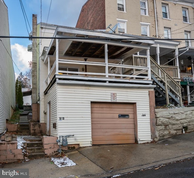 rear view of property featuring a garage and a balcony