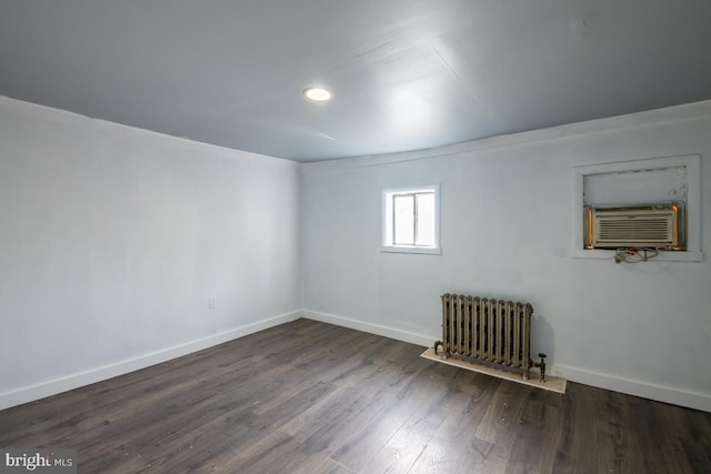 empty room with radiator heating unit, cooling unit, and dark wood-type flooring