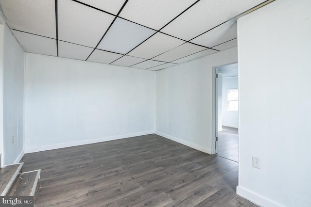 unfurnished room with a paneled ceiling and dark wood-type flooring