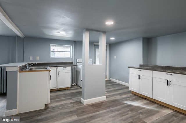 kitchen featuring dark hardwood / wood-style floors, white cabinetry, and sink