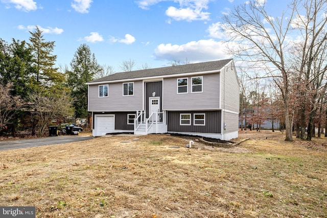 split foyer home featuring a garage and a front yard