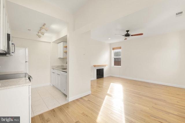 kitchen featuring white cabinetry, ceiling fan, light wood-type flooring, track lighting, and white dishwasher