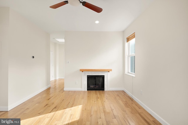 unfurnished living room with light wood-type flooring and ceiling fan