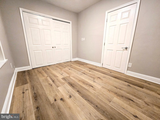 unfurnished bedroom featuring light wood-type flooring and a closet