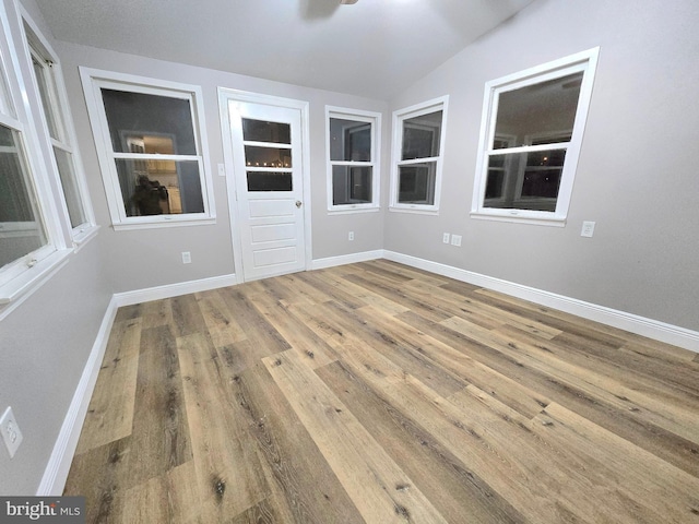 unfurnished room with hardwood / wood-style flooring and vaulted ceiling