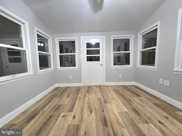 spare room with hardwood / wood-style floors and lofted ceiling