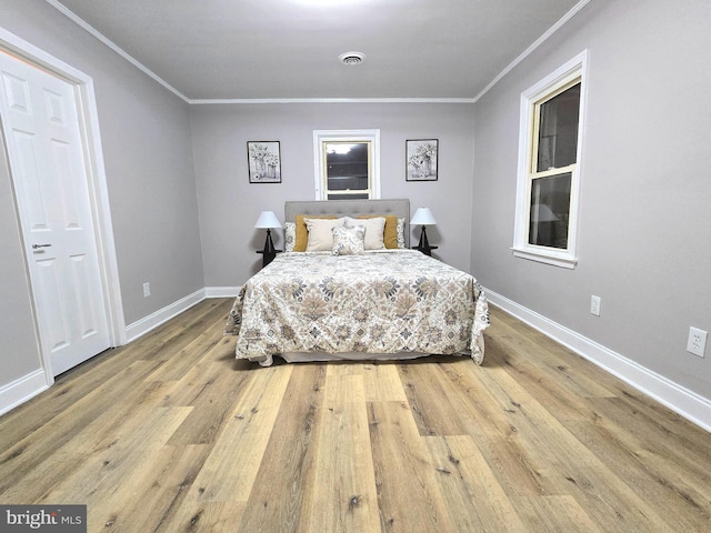 bedroom with light hardwood / wood-style floors and ornamental molding