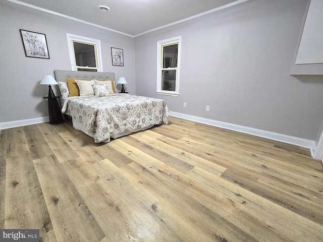 bedroom with light hardwood / wood-style flooring and ornamental molding