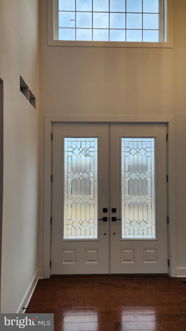 foyer entrance featuring french doors, plenty of natural light, a high ceiling, and dark hardwood / wood-style floors