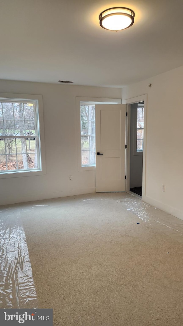 carpeted empty room with a healthy amount of sunlight