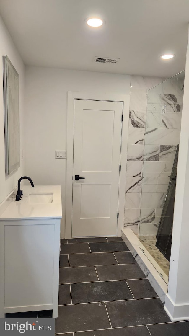 bathroom with vanity and a tile shower