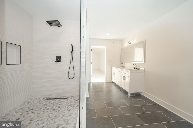 bathroom featuring a tile shower, tile patterned floors, and vanity