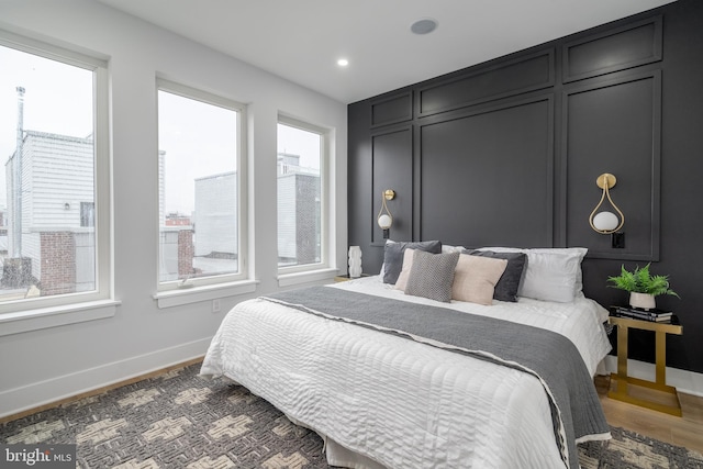 bedroom with dark wood-type flooring and multiple windows