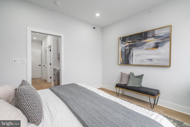 bedroom featuring light hardwood / wood-style floors and connected bathroom