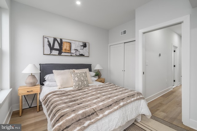 bedroom with light hardwood / wood-style floors and a closet