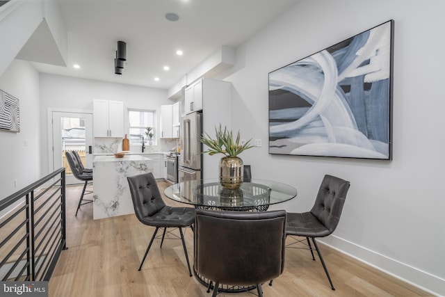 dining area featuring sink and light hardwood / wood-style floors