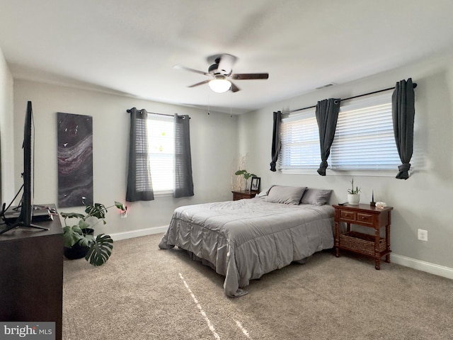 carpeted bedroom with multiple windows and ceiling fan