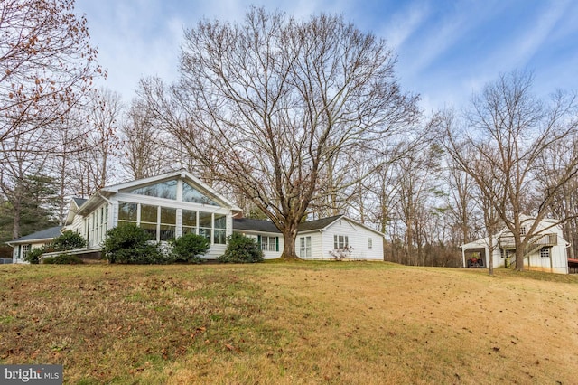 exterior space featuring a lawn and a sunroom