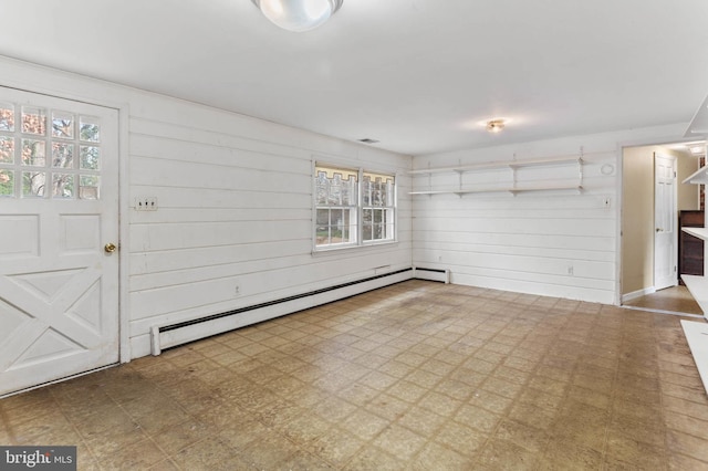 foyer entrance with a healthy amount of sunlight, wooden walls, and a baseboard radiator