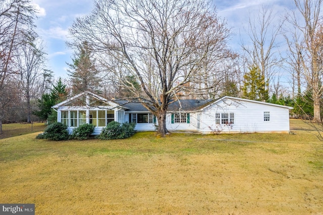 view of front of house with a sunroom and a front lawn