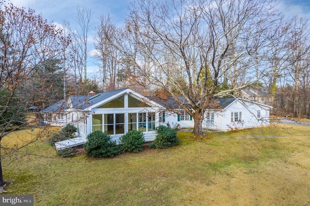 back of house featuring a yard and a sunroom