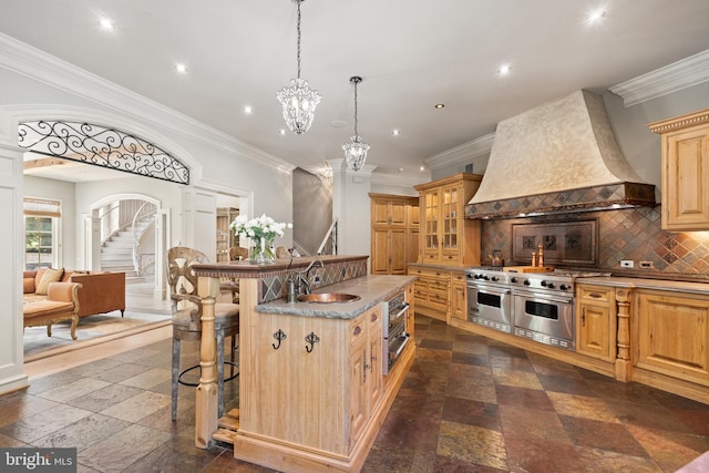 kitchen with a breakfast bar, sink, decorative backsplash, double oven range, and custom range hood