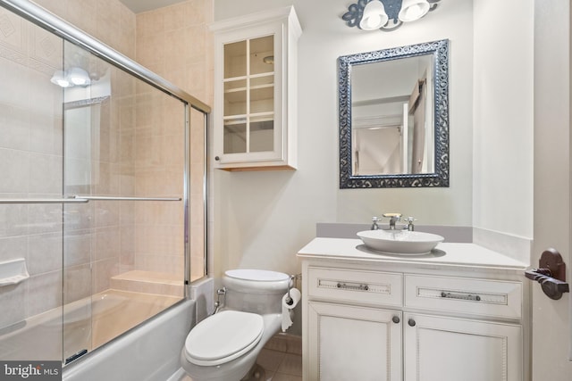 full bathroom featuring bath / shower combo with glass door, vanity, and toilet