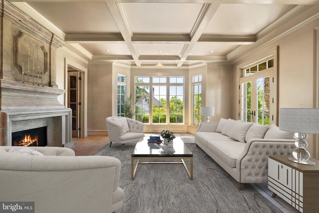 living room with hardwood / wood-style floors, beam ceiling, coffered ceiling, a high end fireplace, and ornamental molding