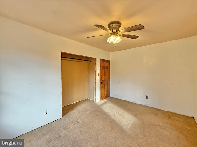 unfurnished bedroom with ceiling fan, a closet, and light colored carpet